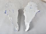 two pieces of white plaster are sitting on a table next to a ruler