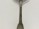 silver spoon with a blue flower on it sitting on a white surface