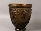 a brown vase with birds on it on a table