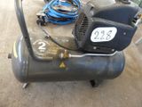 a black air compressor sitting on a table in a garage