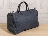 the black duffel bag is sitting on a table in front of a wall