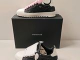 deux paires de baskets noires et blanches ornées de nœuds roses