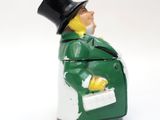 a green and white figurine of a man in a top hat