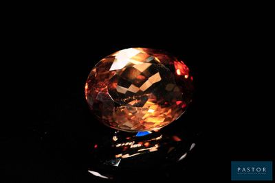 gros plan d'un diamant orange sur une surface noire