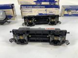 three toy trains sitting on top of a table next to boxes of boxes