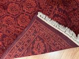 a close up of a red rug on a wooden floor
