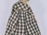 an old fashioned doll with a black and white checkered dress and hat