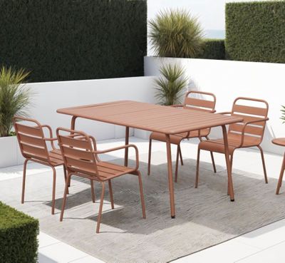 une table et des chaises sur une terrasse recouverte d'un tapis