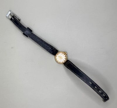 une image représentant une montre posée sur une table, sur fond blanc