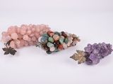 trois perles de couleurs différentes et une grappe de raisin sur un fond blanc