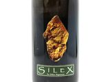 a bottle of wine with a piece of gold on it