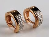 une paire de boucles d'oreilles créoles en or et diamants sur fond blanc