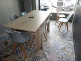 une table et des chaises en bois dans une pièce au sol carrelé