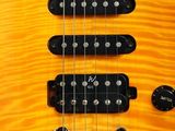a close up of a yellow electric guitar on a white background