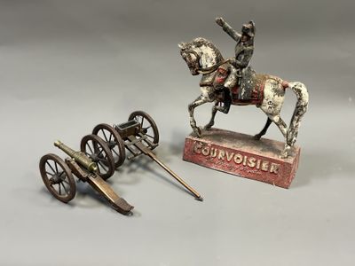 une statue représentant un homme à cheval, à côté d'un canon