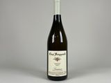 une bouteille de vin posée sur une table à côté d'une bouteille de vin