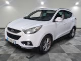 la voiture blanche est garée sur un sol en damier dans le garage