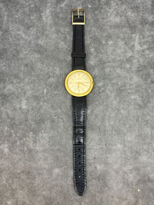 un gros plan d'une montre-bracelet posée sur une surface grise