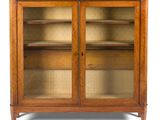une vieille armoire en bois avec des portes vitrées et un plateau en marbre