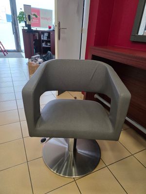 une chaise grise dans une pièce aux murs rouges