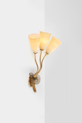 a close up of a wall light with three flowers on it