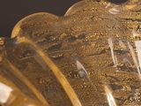a glass vase that has a gold decoration on it
