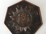 a metal plaque with a sunburst and a clock on it