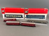 two red and silver train cars sitting next to each other on a table