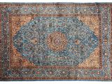 un tapis bleu orné d'un motif en médaillon sur fond blanc