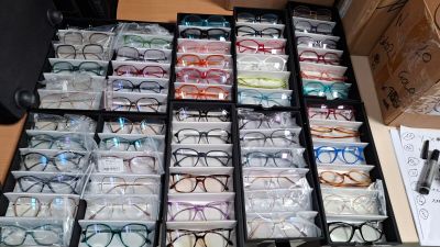 many boxes of glasses and pens on the table