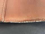 an image of a brown leather wallet sitting on top of a black table