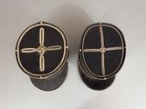 two black and gold boxes with crosses on them sitting on a white surface