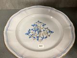 a close up of a white plate with blue and gold designs on it