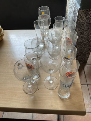 a lot of empty glasses on a table with a basket on the side