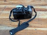 a camera strap attached to a camera on a wooden table