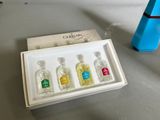 four bottles of perfume sitting in a box on a table
