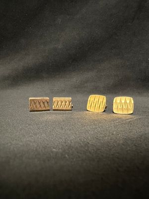 three pairs of wooden stud earrings sitting on top of a black surface