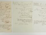 three pieces of paper with writing on them sitting on a table