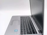 a silver laptop computer sitting on top of a white table