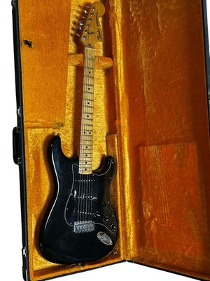a black electric guitar in a case on a white background