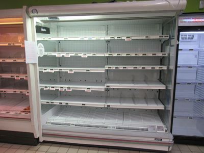 an empty refrigerator in the middle of a store
