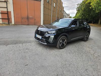 un SUV noir garé sur un parking à côté d'un immeuble