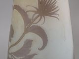 a white vase with a brown floral design on it