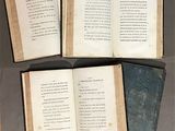 several open books on display in a glass case on a table