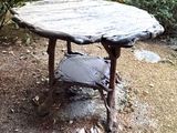 a wooden table that is sitting in the middle of the woods