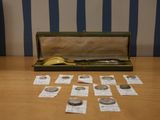 une boîte de pièces et une paire de ciseaux posés sur une table