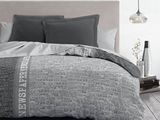 une photo d'un lit avec une couette grise et blanche