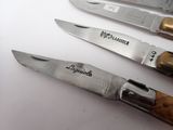 several knives are lined up on a white surface with a logo on them
