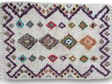 un tapis blanc orné de losanges multicolores et de franges