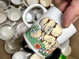 a person holding a coffee cup in a box full of cups